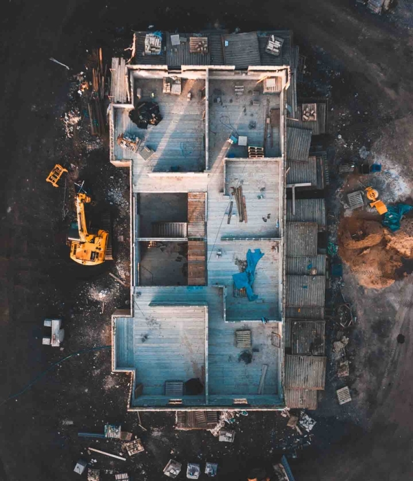Aerial birds eye image of the frame of a house being built on a construction site at sunset - Wooden floor and walls are visible